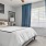 a bedroom with a bed and curtains open for natural light