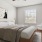 a bedroom with a bed and a chair set up in the corner