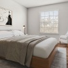 neutral styled bedroom with bed side tables with lamps and painting above bed frame