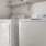 washer and dryer with shelves above it